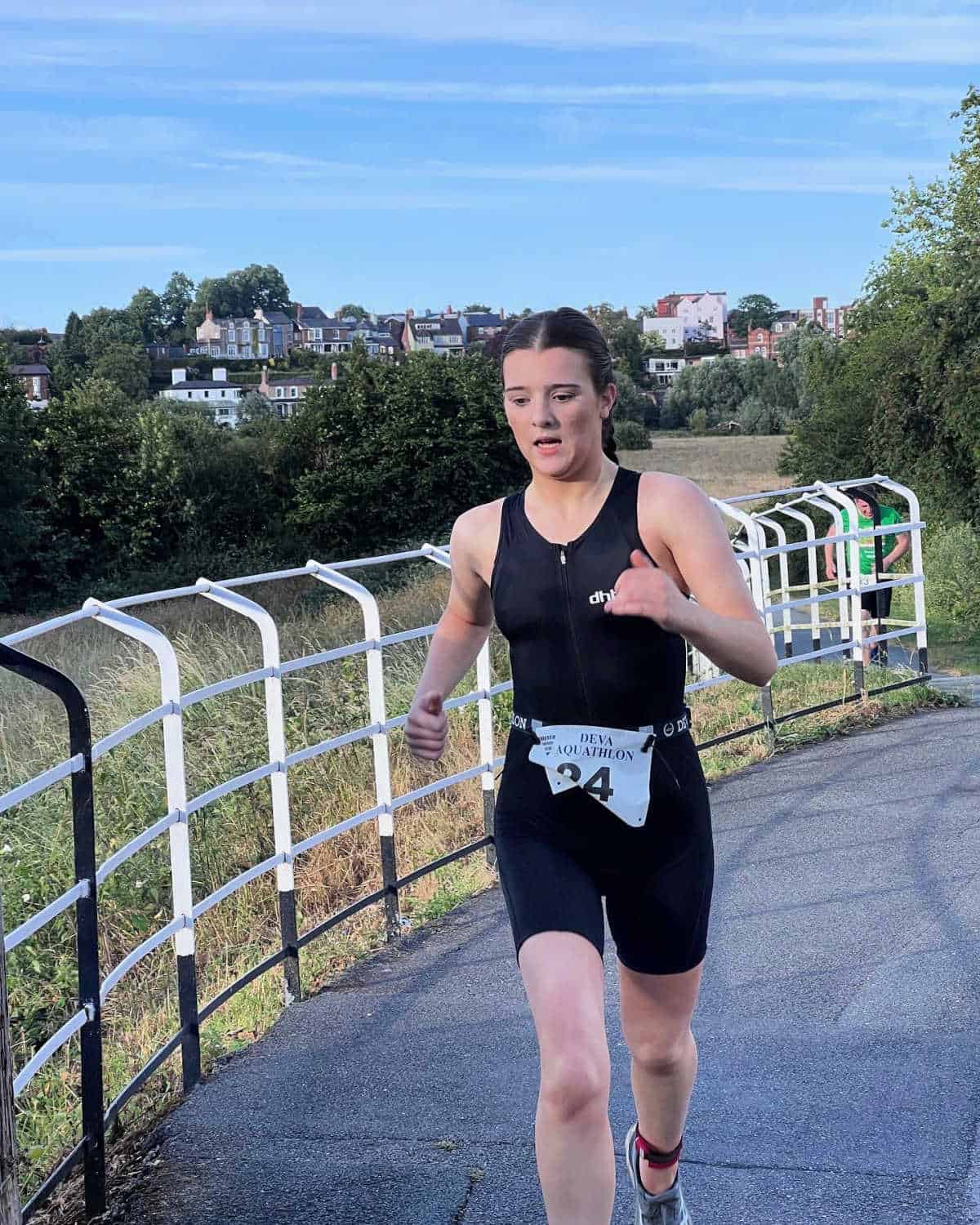 teenage girl running wearing a black training suit