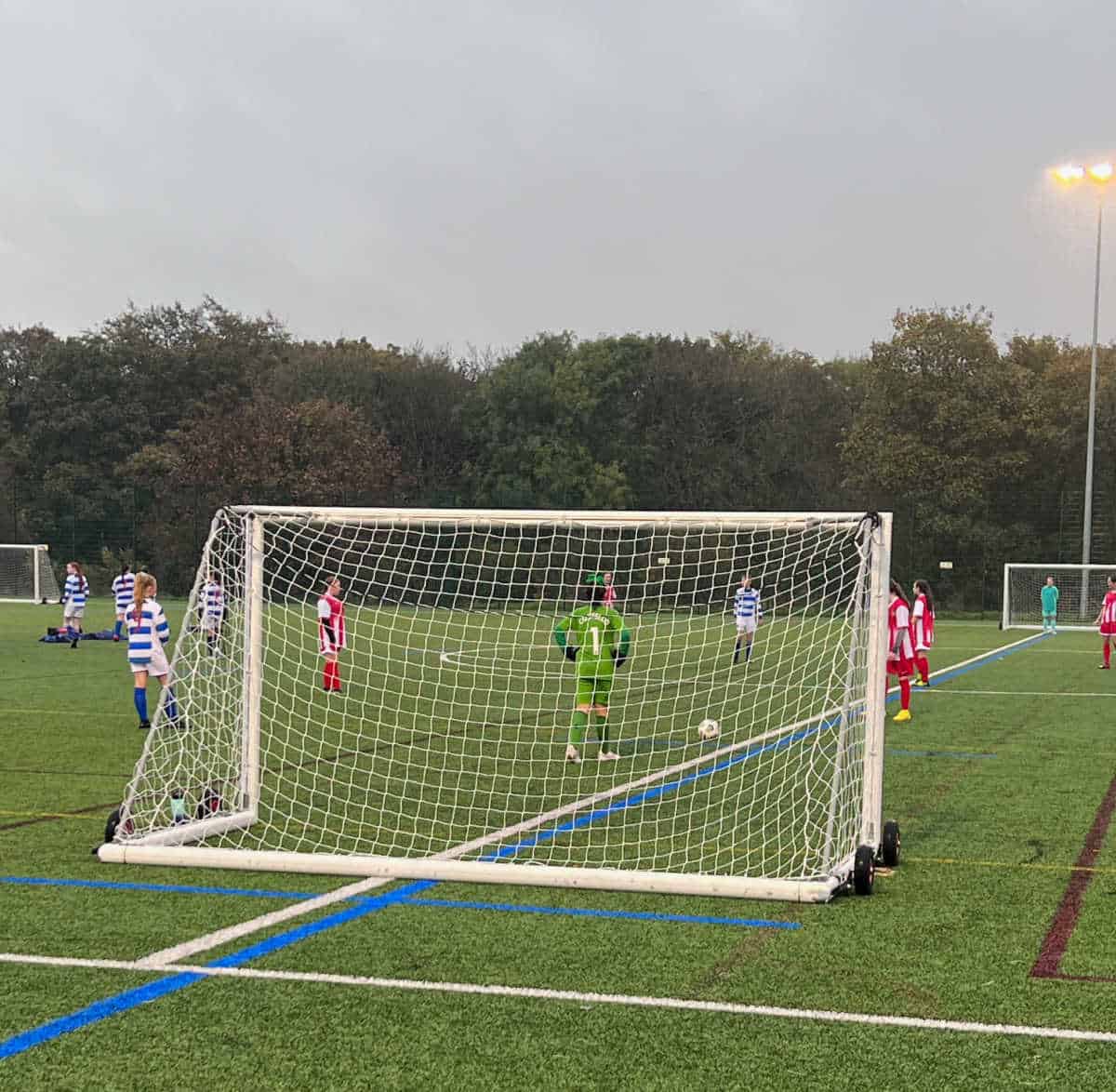girl goalkeeper by her goal waiting to kick the ball