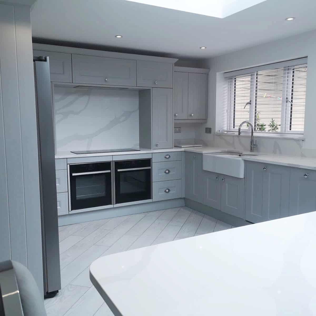a very clear grey and white kitchen with nothing on the worktops