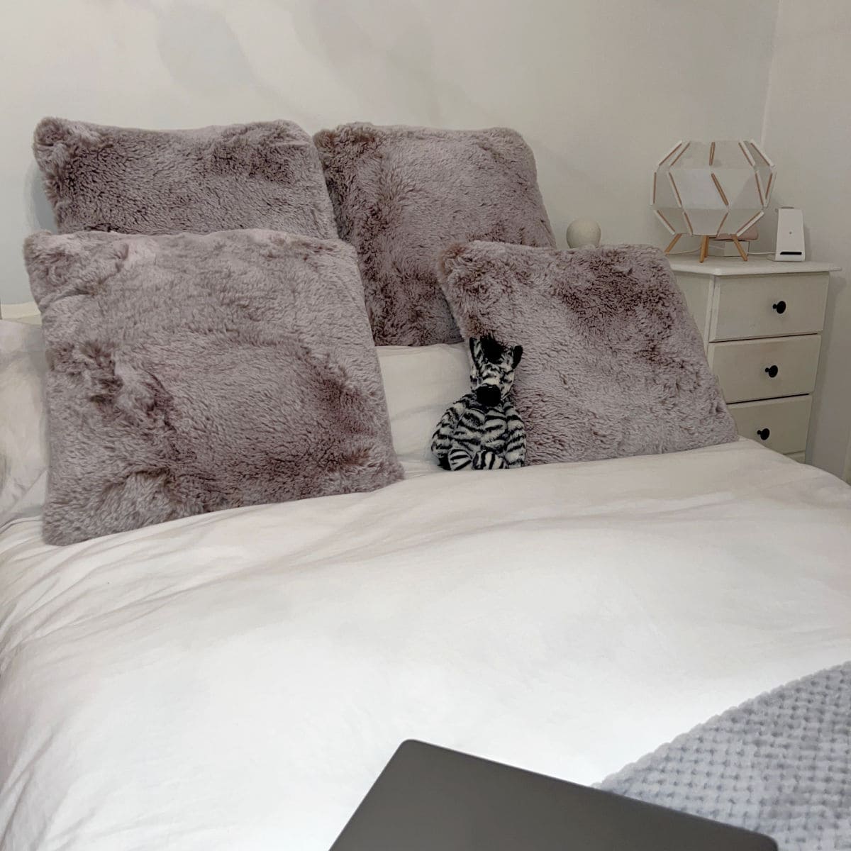 double bed with white covers and grey cushions