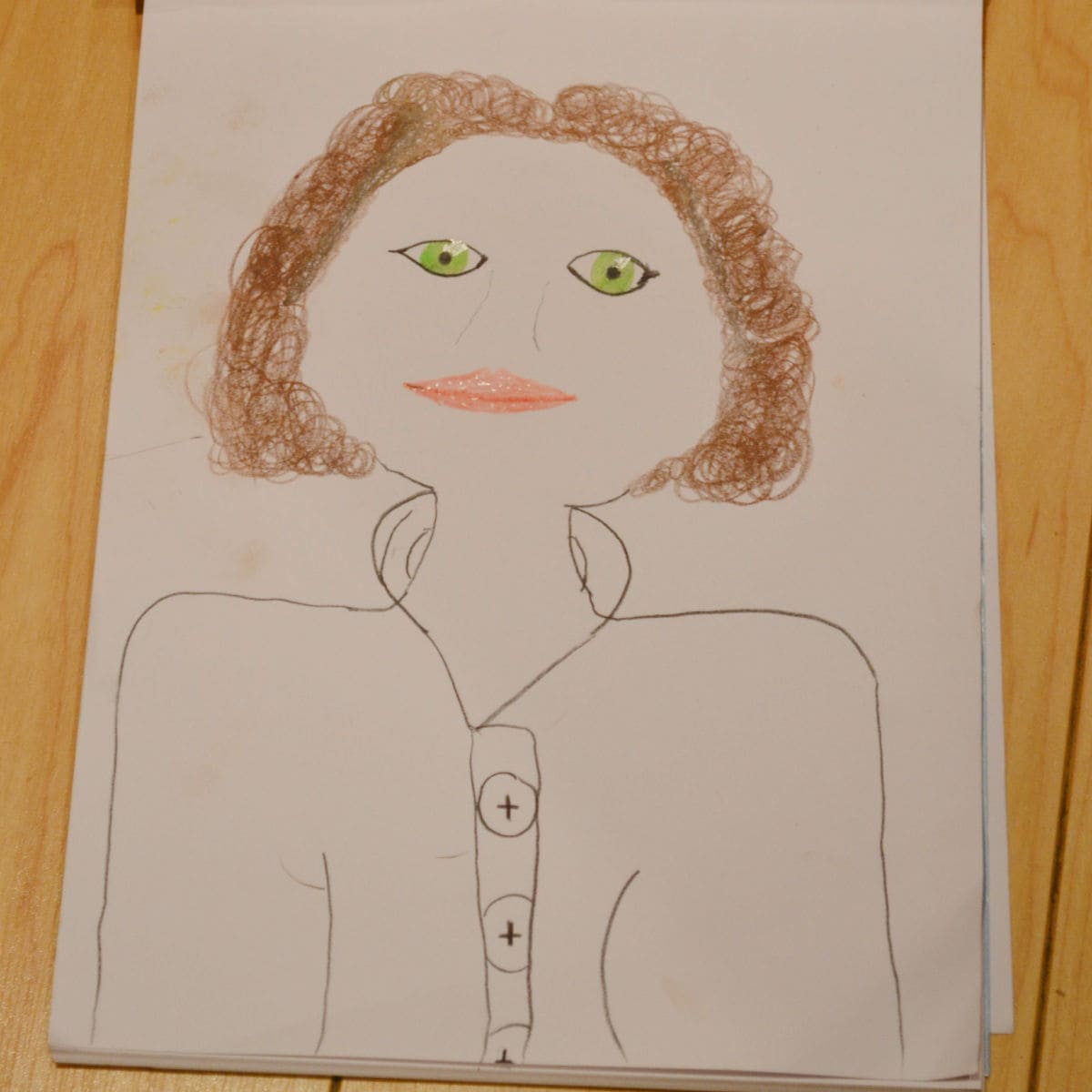 drawing of a lady with brown curly hair and green eyes on white paper